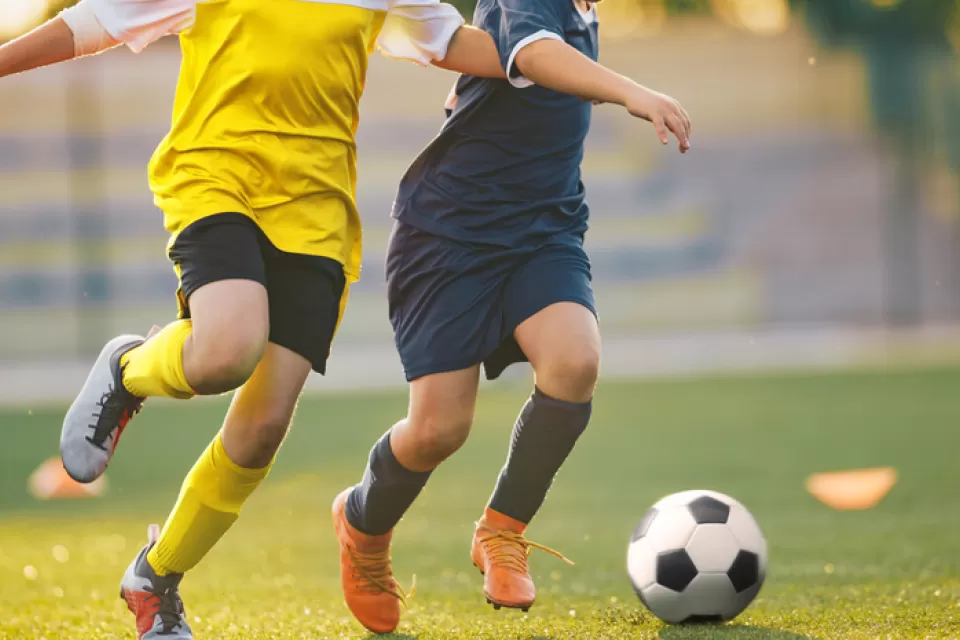 Two soccer players chasing a ball